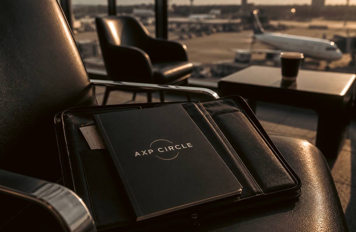 Material de AXP CIRCLE sobre un portafolio en una sala de aeropuerto.
